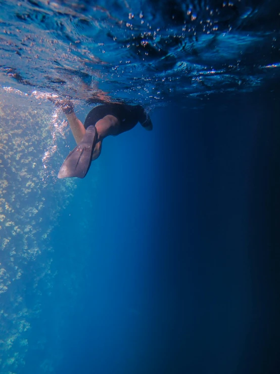 a woman swimming in the ocean while wearing a swim suit