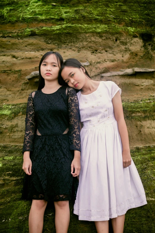 two women standing next to each other wearing dresses