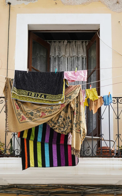 several brightly colored towels are on a balcony