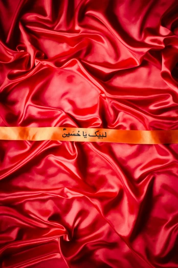 the yellow ribbon has been folded and is on the red fabric