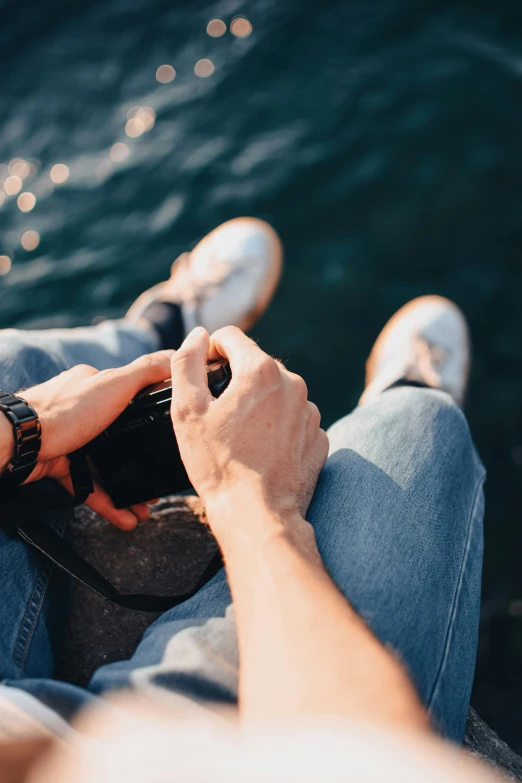 a person that is texting on his phone near water