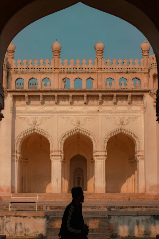 a person with a black backpack walks by an archway