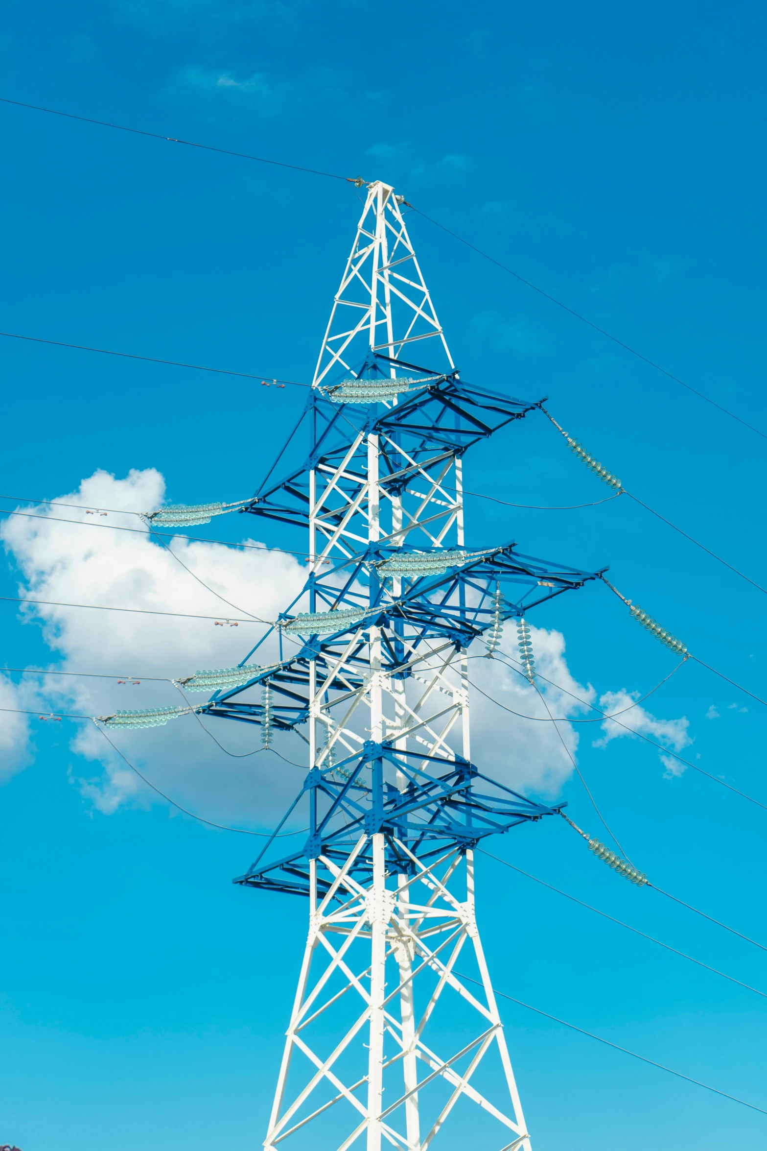 a tall white power pole with electrical wires above it