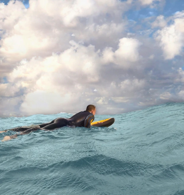 a man laying on a surfboard in the ocean