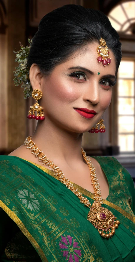 a young woman wearing an ornate green saree and matching jewelry