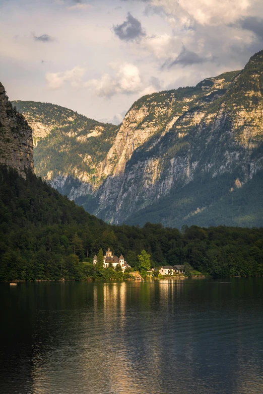 the mountains are surrounded by a lake near buildings