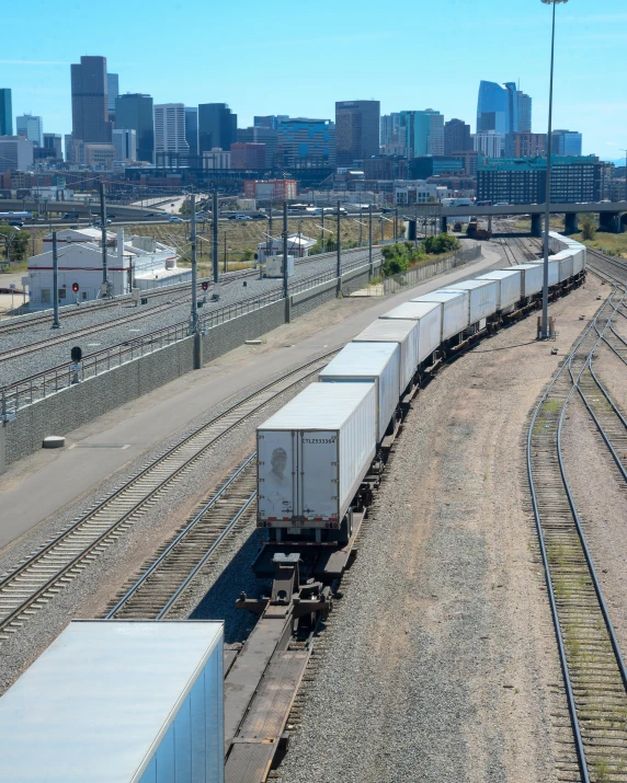 a long train traveling past a large city in a rural country