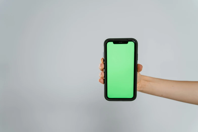 a hand holding a green screen phone with a green screen