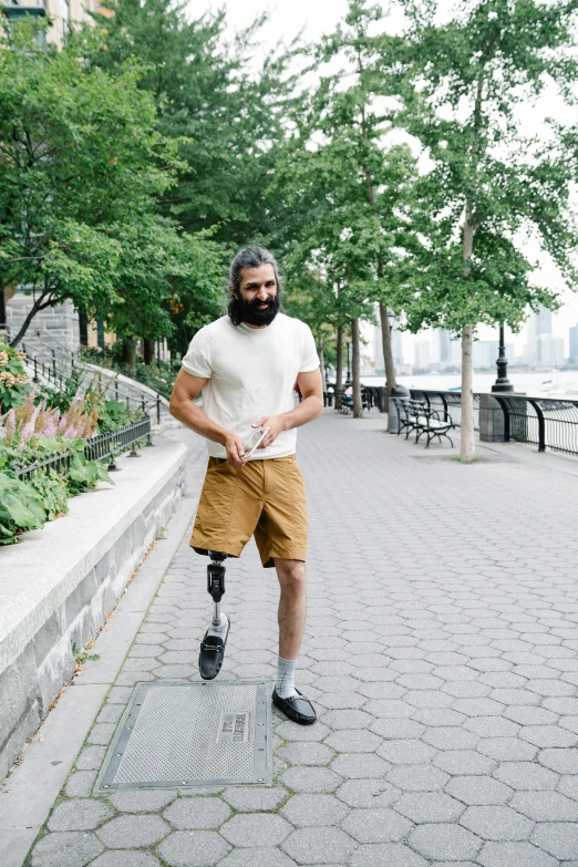 the man is walking down a sidewalk using a knee ce