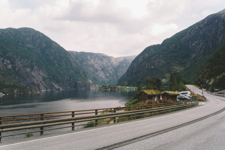 the view of a highway going beside mountains