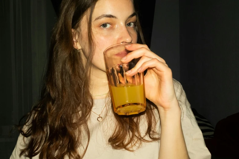 the young woman is sipping from the glass