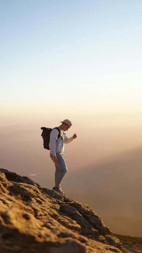 a man standing on top of a mountain with a backpack