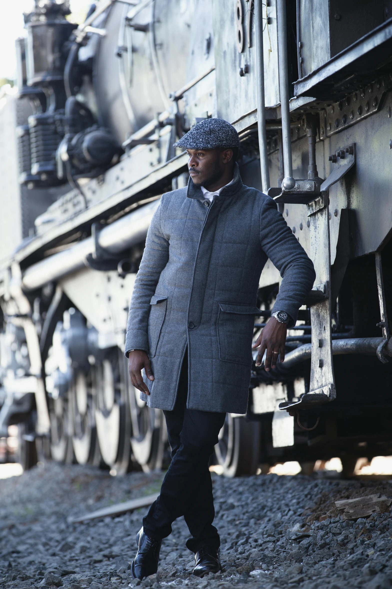 a black man is standing near a train