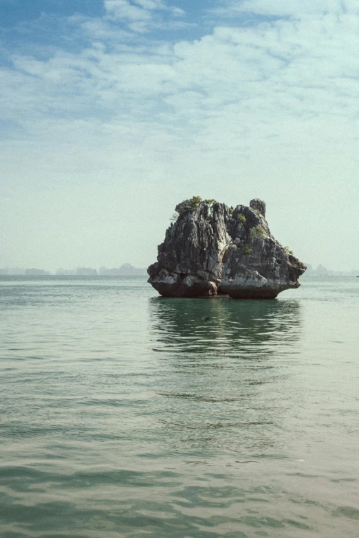 a large rock in the middle of the ocean