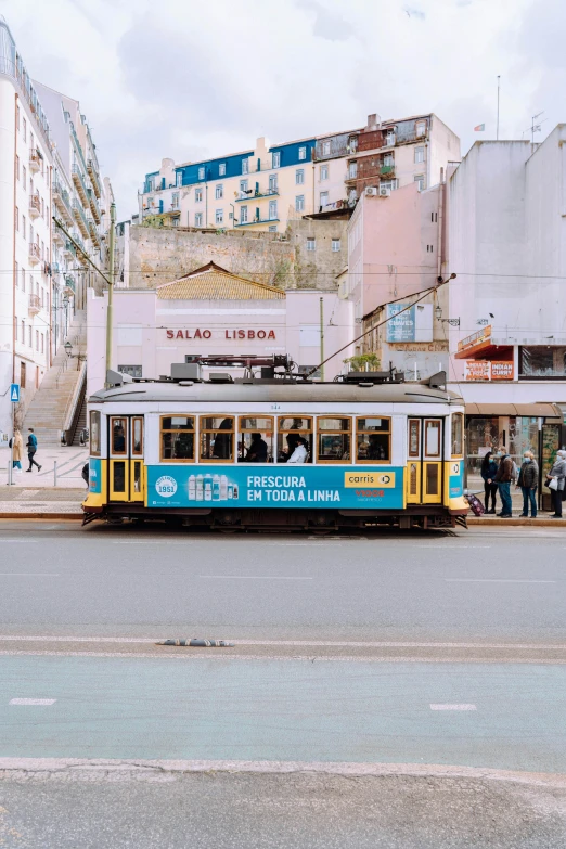 people are standing on the side of the street near a trolley car