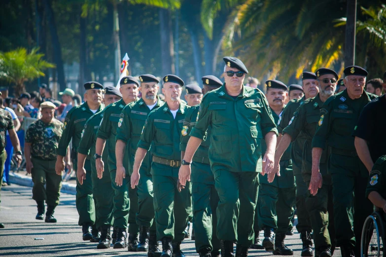 a large group of men in uniforms marching down the street