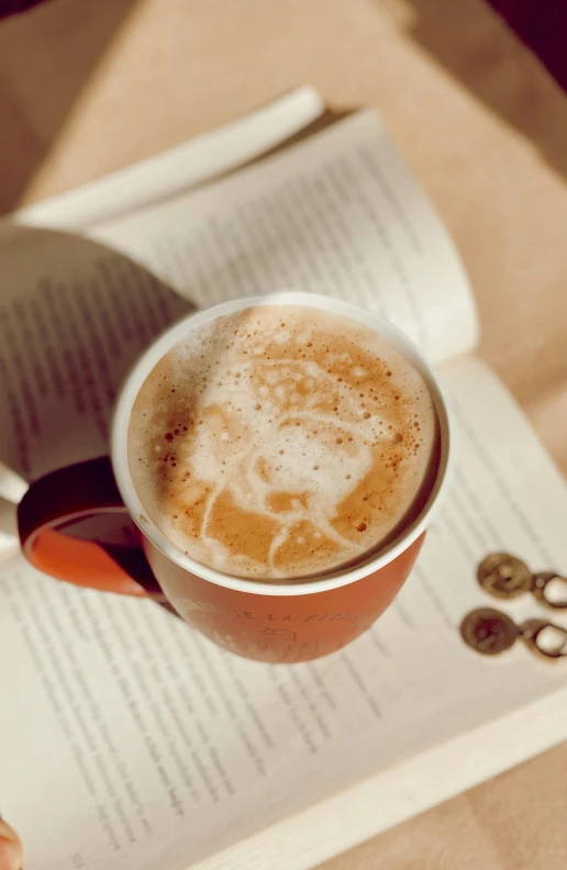 a book sitting on top of a table next to a cup