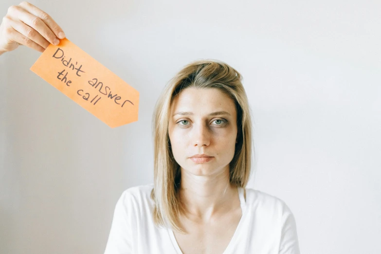 a woman standing with an orange tag written on her head