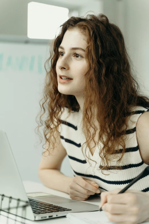 a woman sitting in front of a laptop computer