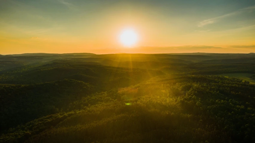 the sun setting over a mountainous valley