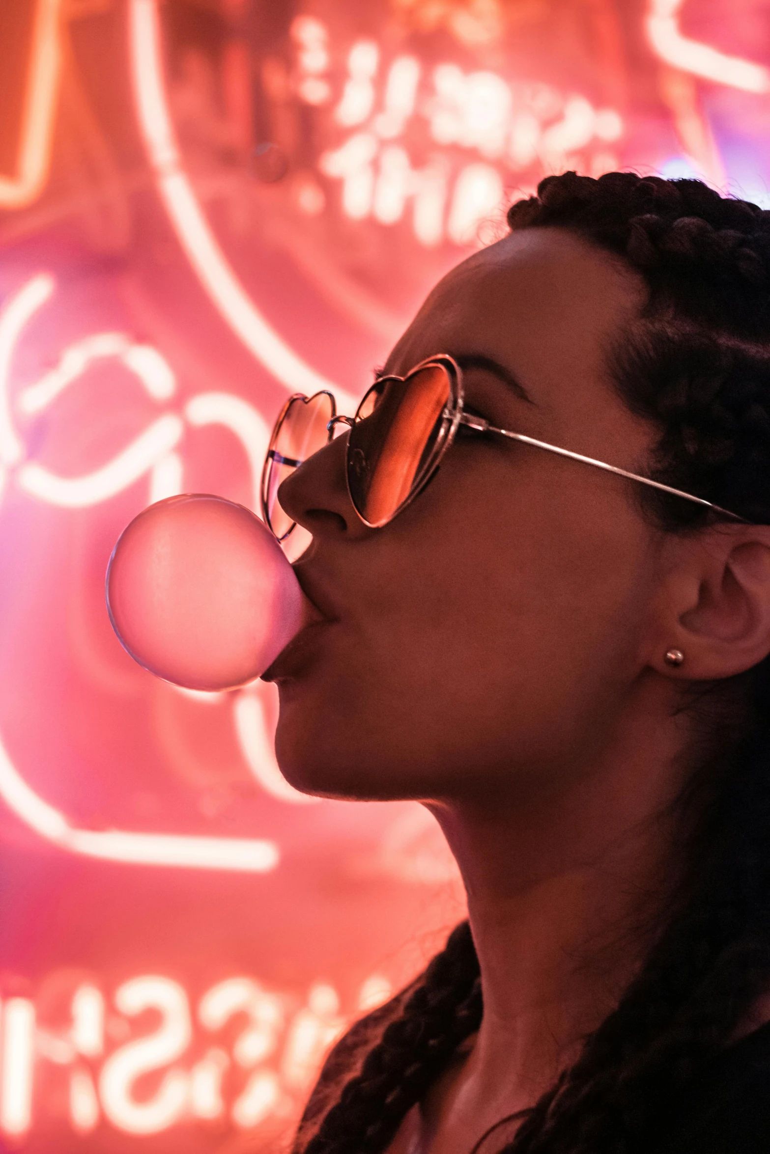 a woman with her tongue out and bubble attached to her nose