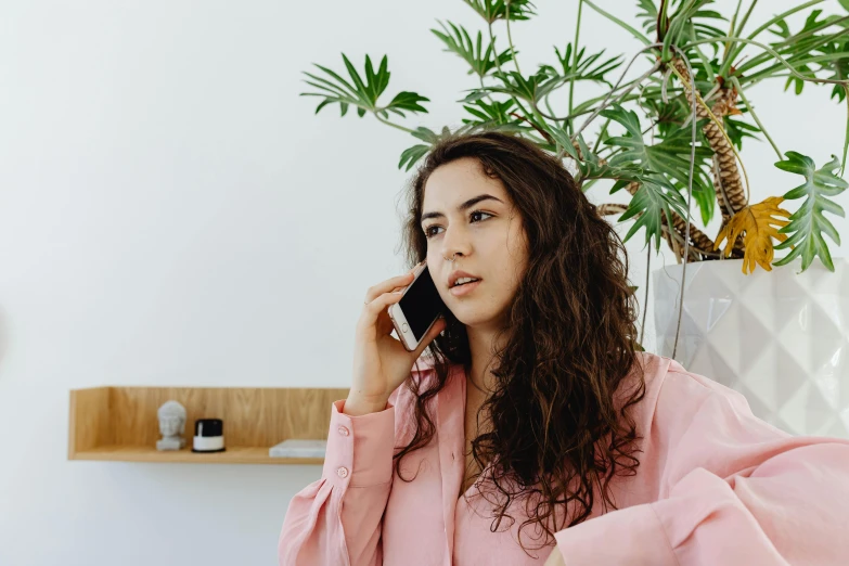 a young woman is sitting in the corner while talking on the phone