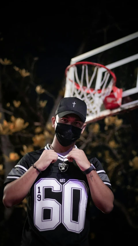 a person in a uniform and a mask standing by a basketball hoop
