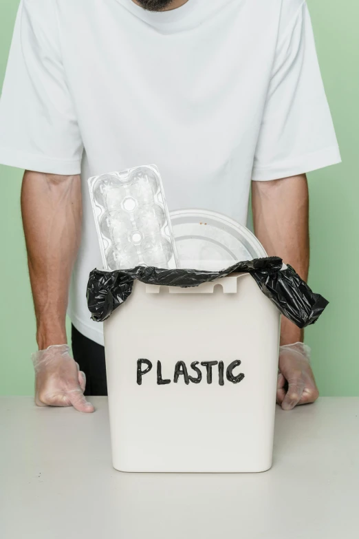 a man holding a plastic container with gloves and gloves over it