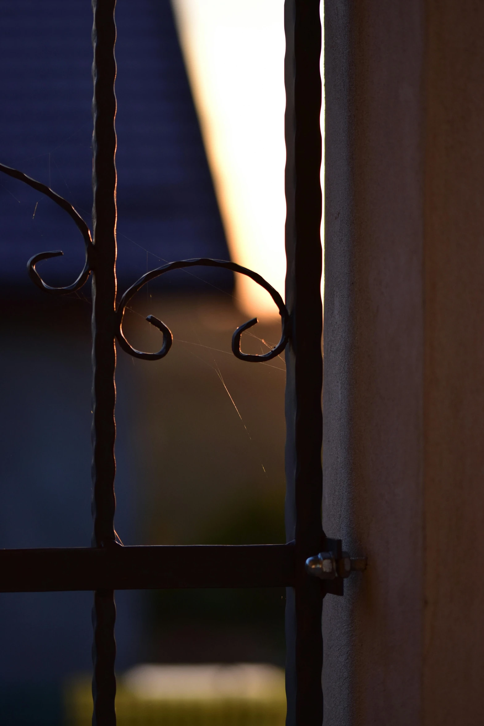 the corner of a gate with metal bars in front of it