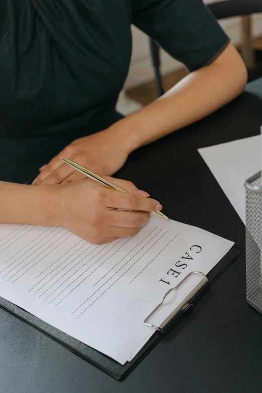 a woman with a pencil and a pen writing soing in a notebook