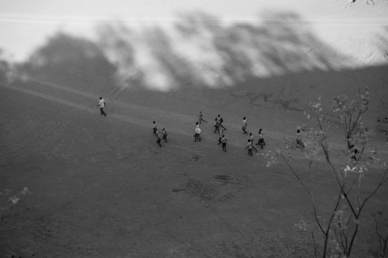 a group of people walking in a field near some grass