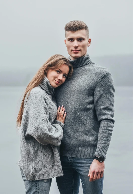 the couple is posing for a picture near the water