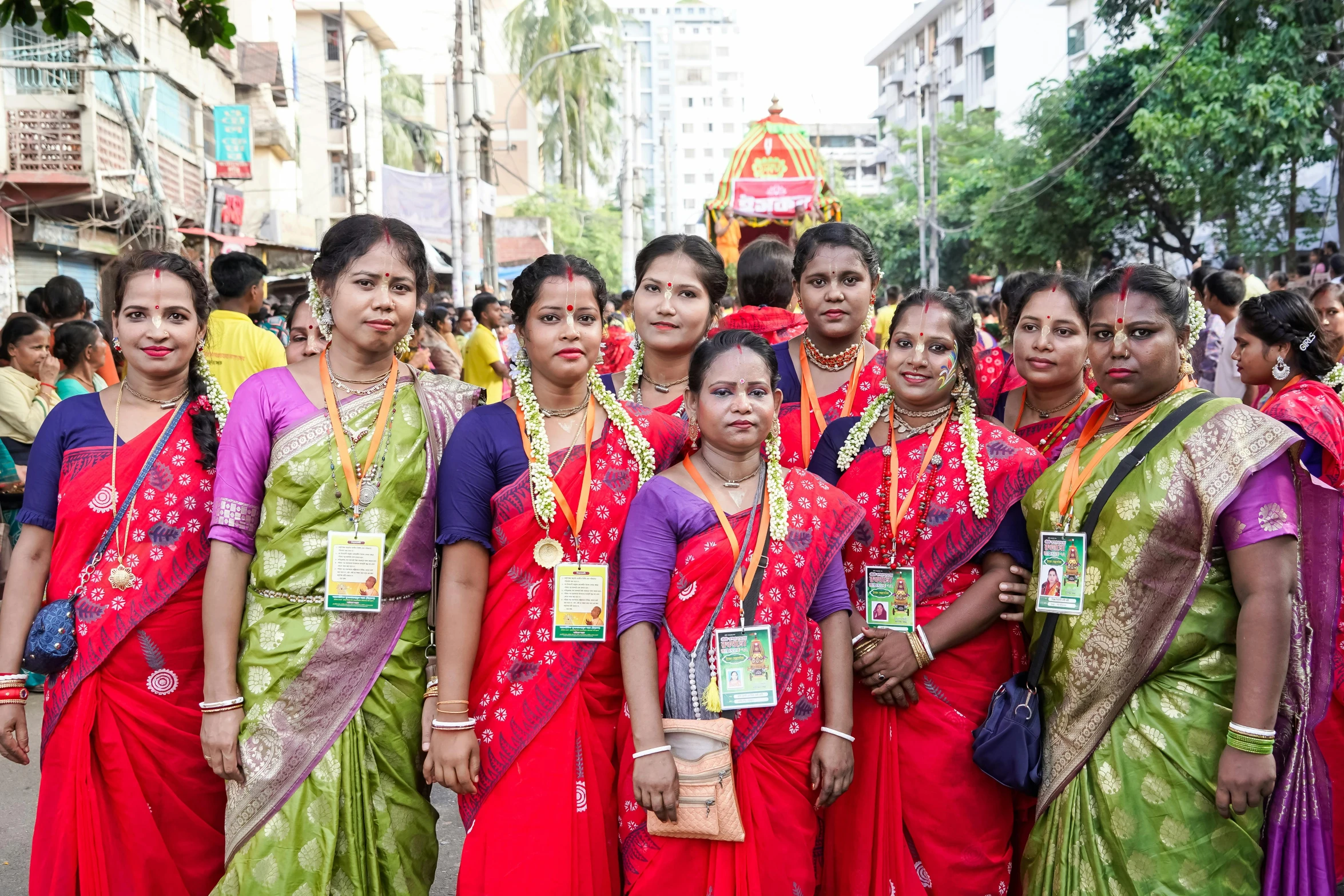 a group of women standing next to each other in matching saris