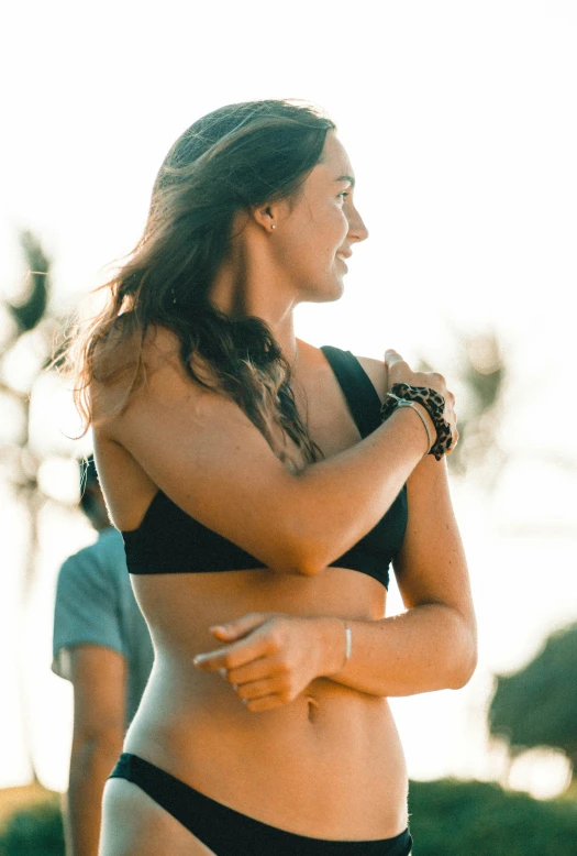 a woman in a black bikini standing next to another woman