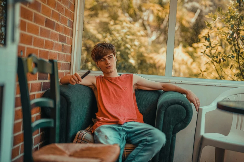 a young man sits on the couch in the corner