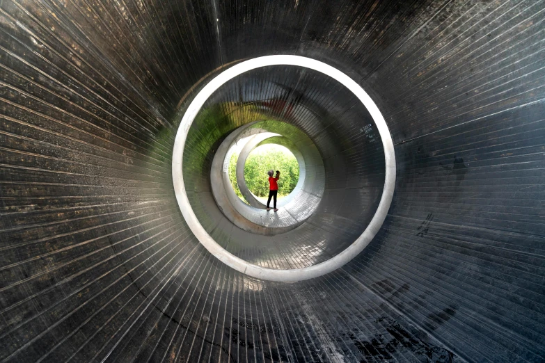 a man standing inside of a large metal tube