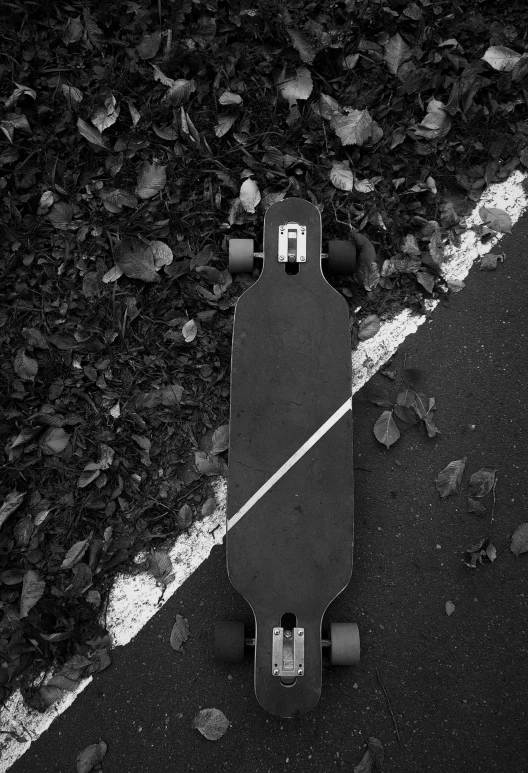 an old skateboard with wheels sits on the side of the road