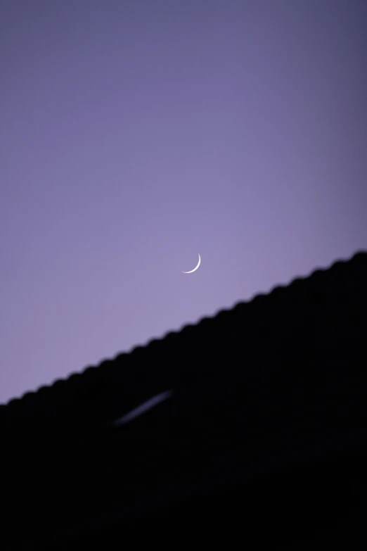 an airplane flying in the sky with a moon and half moon