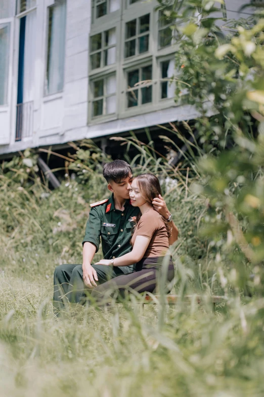 a soldier and a woman are sitting in the tall grass