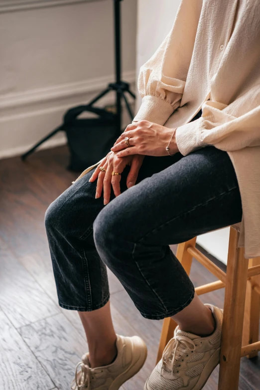 the feet of someone sitting in a chair next to their shoes