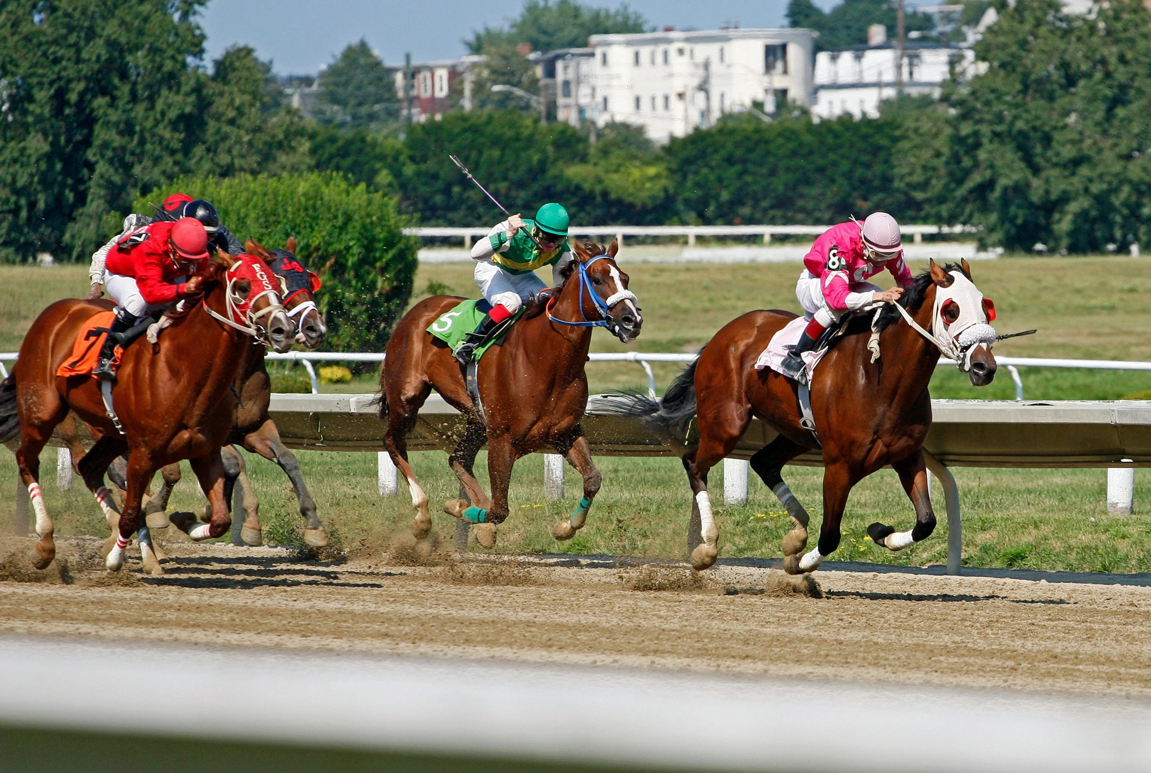 some horse riders are racing horses on the track