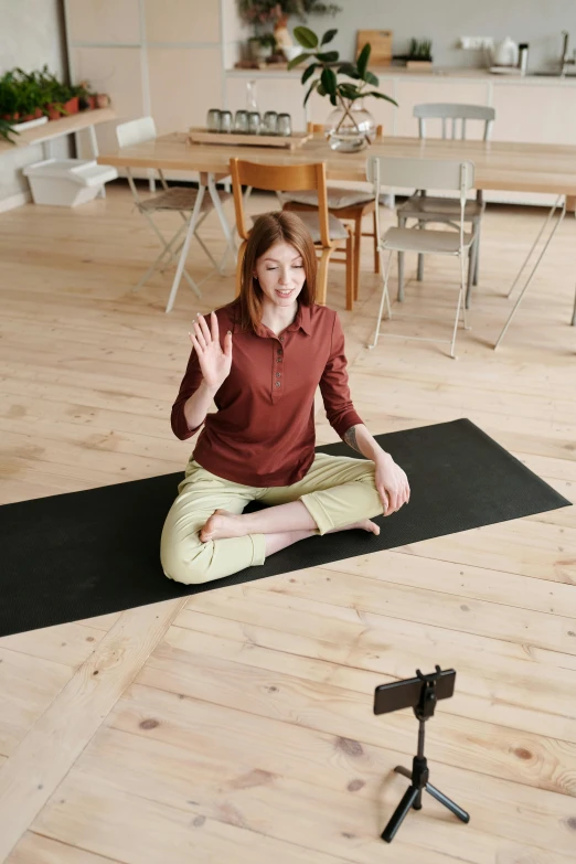 a woman sitting in the middle of a yoga mat and clapping