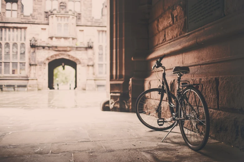 the bike is leaning against the wall by the entrance