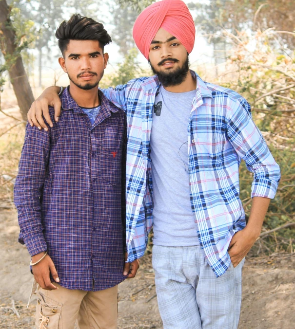 two young men standing side by side in the woods