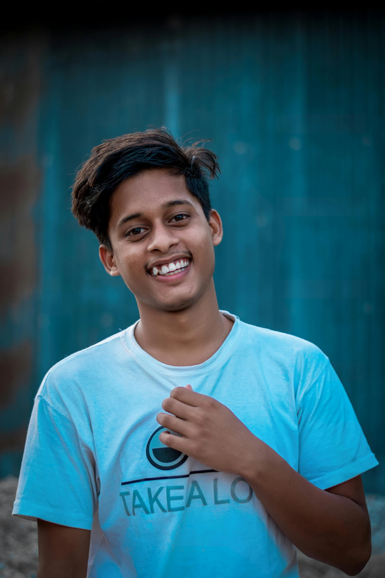 a boy wearing a blue tshirt posing for a picture