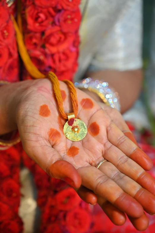 a women's hand holding gold jewelry and beads