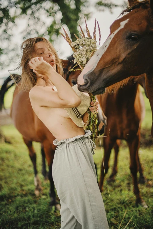 a woman holding a horse next to a brown and white horse