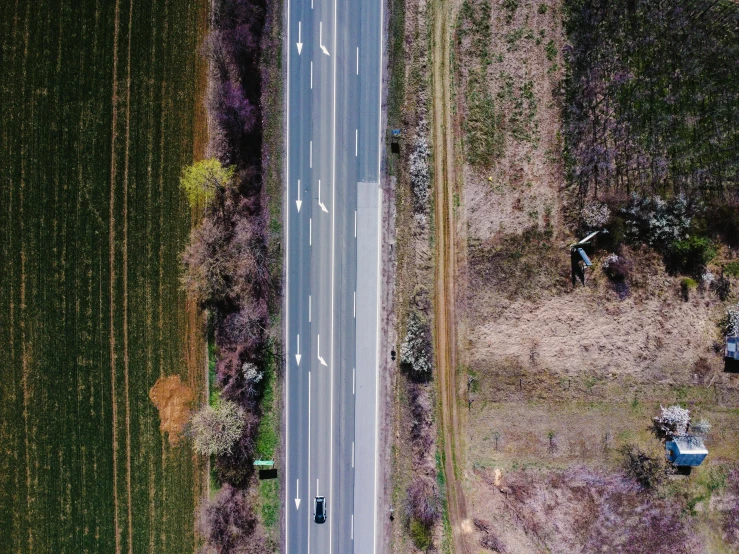 a view from above of the highway that goes through a corn field