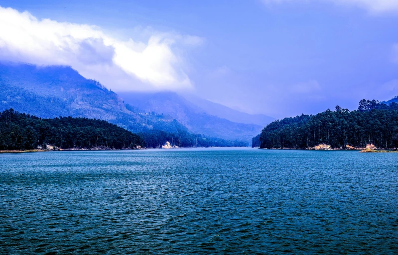 the mountains are behind a large body of water