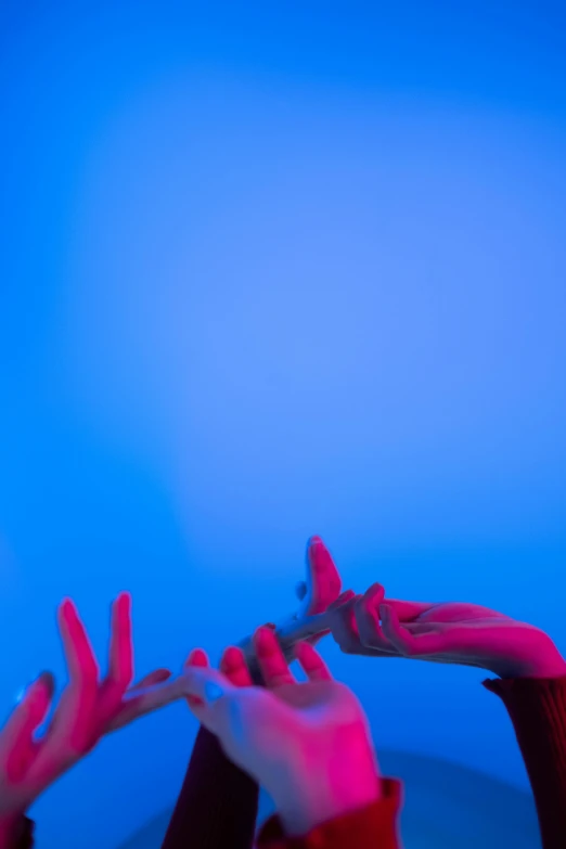 a man holding an object in his hand near a blue background